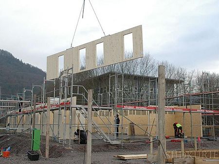 Ein Wandmodul wird auf das Fundament gesetzt. Ein Wandmodul wird auf das Fundament gesetzt.